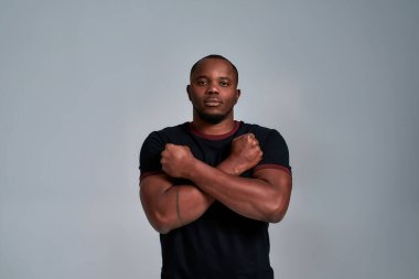 Göğsünde çapraz eller olan Afrikalı Amerikalı genç bir adam.