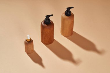 Bej arka planda izole edilmiş farklı boyutlarda ahşap şişeler. Sıfır atık ve ekolojik bilinç