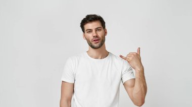 Tişörtlü adam elini kaldırarak havalı bir sembol çiziyor.