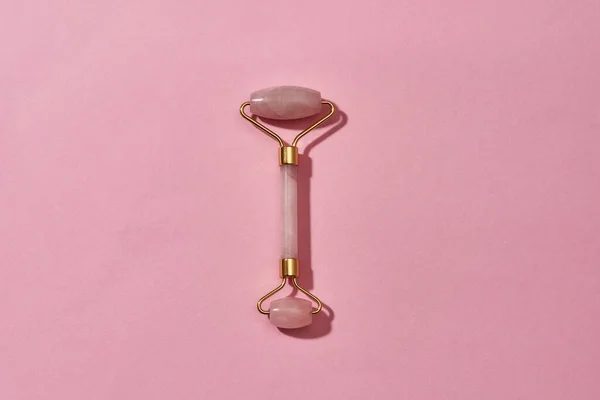 Vista superior do rolo de massagem facial de quartzo rosa isolado sobre fundo rosa — Fotografia de Stock