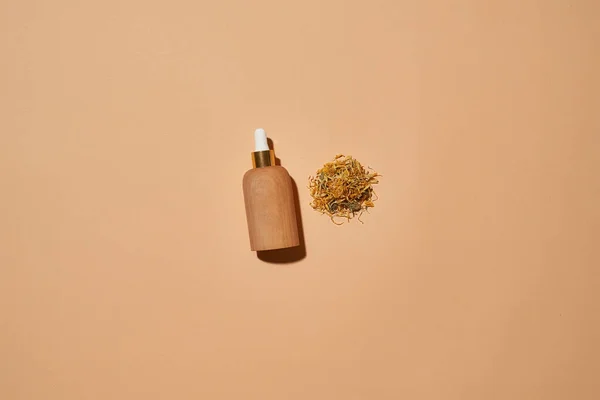 Fles met kosmetologisch product naast bloemblaadjes — Stockfoto