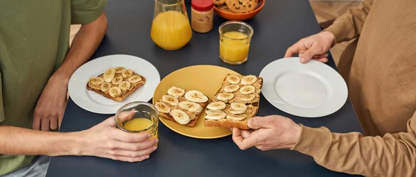 Young same sex pair having breakfast with toasts — Stock Photo, Image