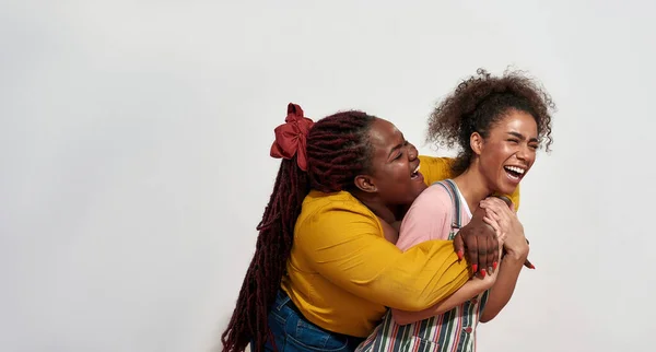 Two African women are having fan on camera hugging with eyes closed and having a great time together — Stock Photo, Image