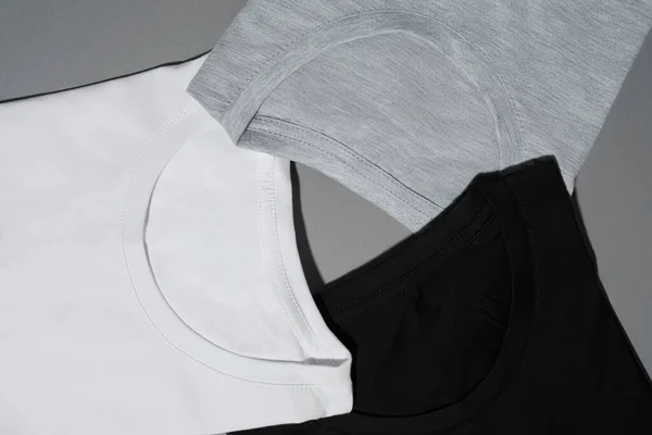 Närbild skott av tre monokrom svart, vit och grå bomull t-shirts. Mall för platta äggläggande tees — Stockfoto