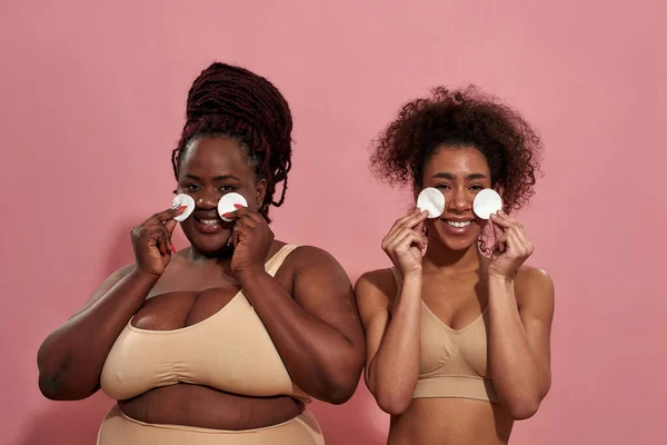 Pareja de amigas afro sosteniendo una esponja en cada mano — Foto de Stock