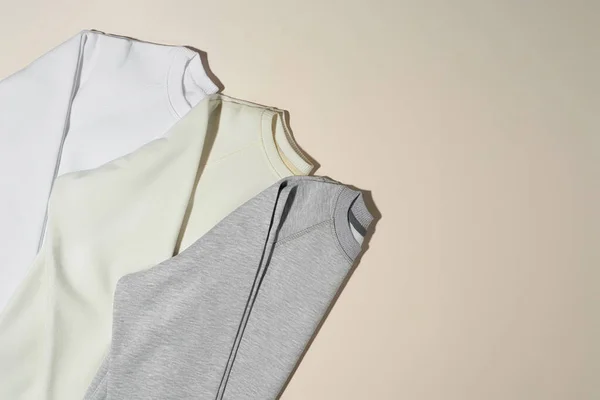 회색, 흰색, 상아 스웨터 가 옅은 베이지 색 배경에 분리되어 있다 — 스톡 사진