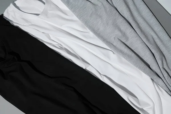 Close up tiro de três camisetas de algodão monocromático simular no fundo cinza — Fotografia de Stock