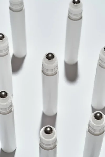 Primer plano de tubos para productos de belleza de rodillos oculares aislados sobre fondo blanco con reflexión —  Fotos de Stock