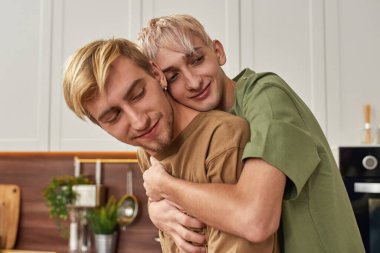 Modern mutfakta kucaklaşan mutlu romantik erkek çifti