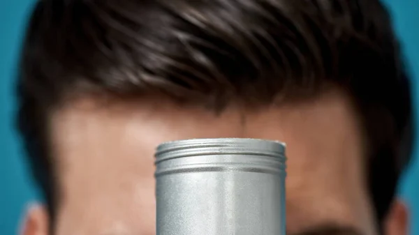 Closeup tiro de frasco de prata com gel ou creme de cabelo styling produto com cabeça masculina no fundo — Fotografia de Stock