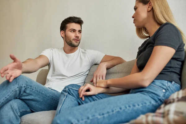 Vista inferior de una pareja joven teniendo un diálogo mientras se enfría en el sofá —  Fotos de Stock