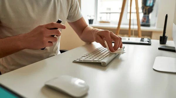 Giovane uomo pulisce e prepara il suo posto di lavoro — Foto Stock