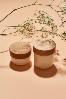 Taze çiçeğin yanında organik yüz kremi şişeleri