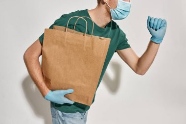 Kafkasyalı genç kurye kağıt paketle koşuyor.