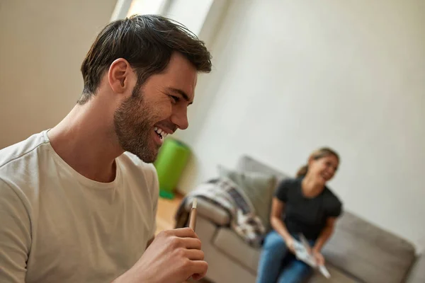 Pareja joven se relaja en la moderna sala de estar y se ríe —  Fotos de Stock