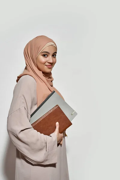 Sorridente giovane donna araba in hijab con blocco note — Foto Stock