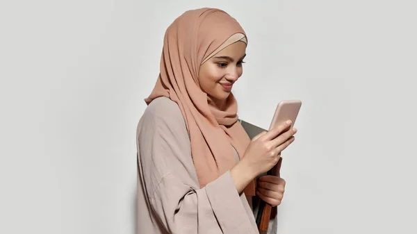 Allegro arabo ragazza studente in hijab utilizzando smartphone — Foto Stock