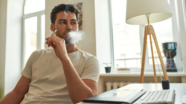 Giovane uomo che fuma sigaretta elettronica e orologi sullo schermo — Foto Stock