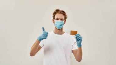 Genç kızıl saçlı kurye baş parmağını kaldırdı ve bir kredi kartı tuttu.