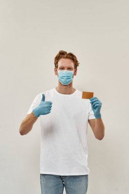 Genç kızıl saçlı kurye baş parmağını kaldırdı ve güvenli ödemeyi kartla yaptı.