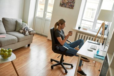 Genç bayan oturma odasında çalışıyor. 