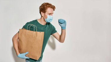 Kafkasyalı genç kurye elinde bir paket kağıt tutuyor.