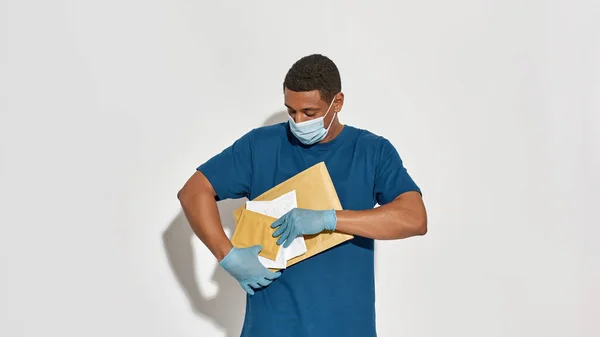 Jovem mensageiro afro-americano segurando pacotes postais — Fotografia de Stock