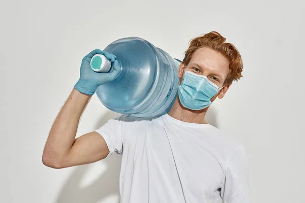 Cropped photo of a young deliveryman in white T-shirt with a huge bottle — Stock Photo, Image