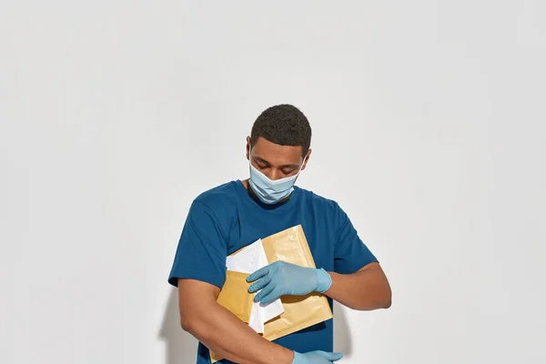 Fiatal afro-amerikai postás levelekkel a kezében — Stock Fotó