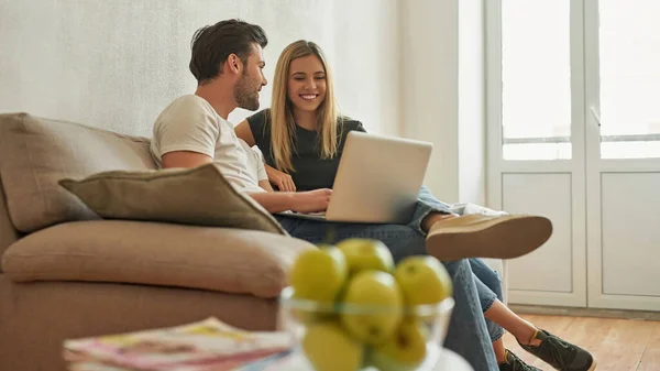 Pareja en el sofá discute algo divertido y se ríe —  Fotos de Stock