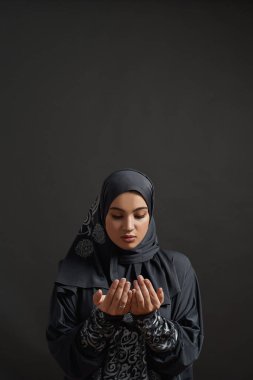 Avuçlarına bakan tatlı, genç bir Arap kadın.