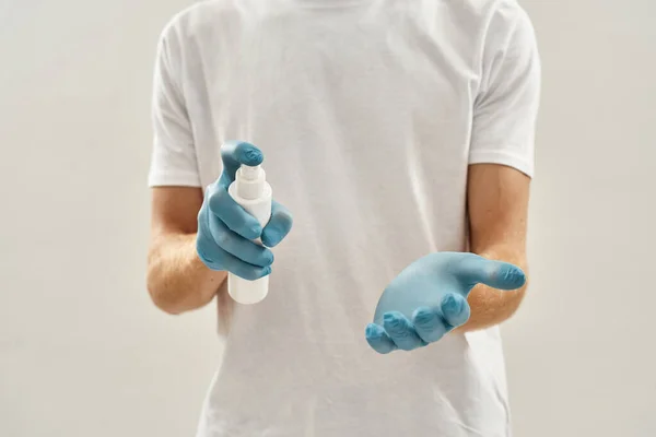 살균제를 들고 장갑을 끼고 있는 손의 모습 — 스톡 사진