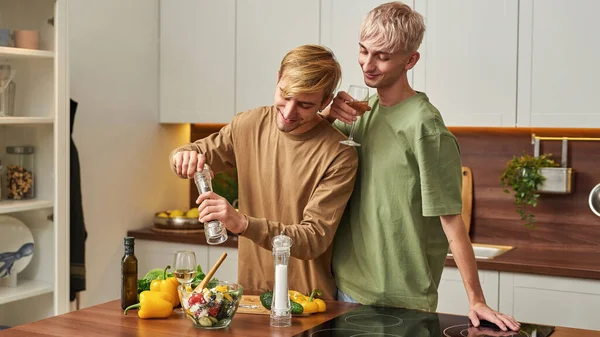 Giovane coppia gay mettere pepe in insalata — Foto Stock