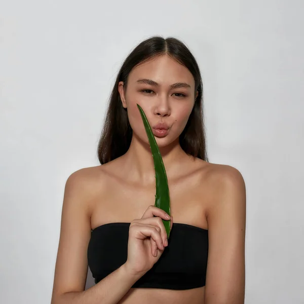 Linda mujer asiática joven sosteniendo hoja de aloe verde —  Fotos de Stock