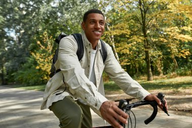 Sırt çantalı bisikletli mutlu Afrikalı Amerikalı adam