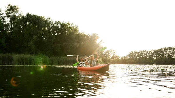 Een paar avontuurlijke vrienden kajakken in een rivier midden in de prachtige natuur op een zomerse dag — Stockfoto