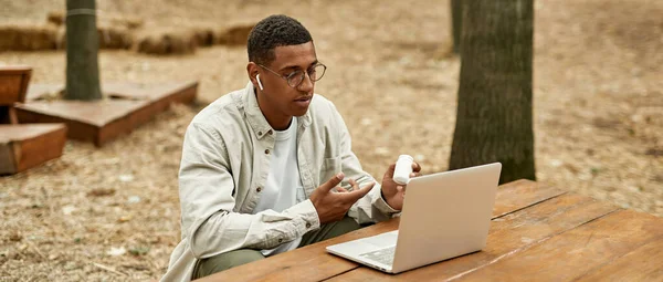 Junger Afroamerikaner blickt in Laptop-Bildschirm — Stockfoto