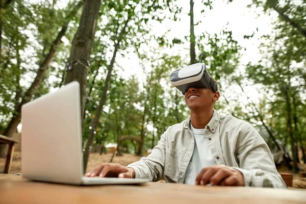 Hombre afroamericano feliz sentado en gafas de realidad virtual —  Fotos de Stock