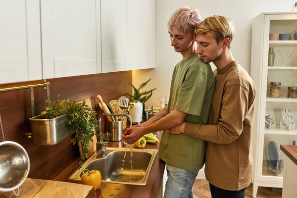 Young same-sex caucasian male couple preparing food