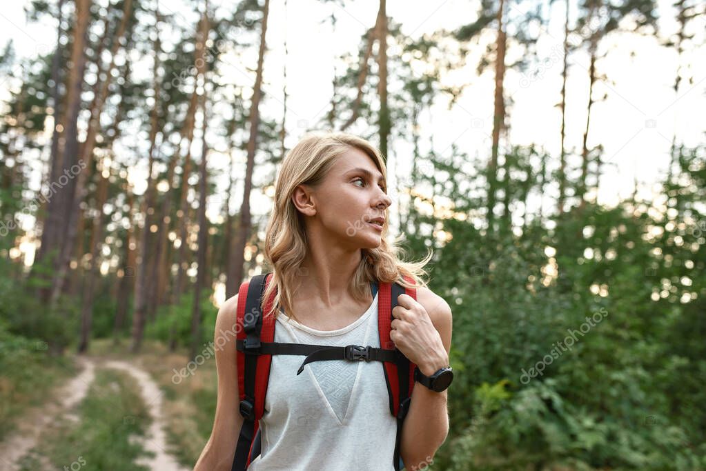 Portrait of young caucasian woman trekking in wood