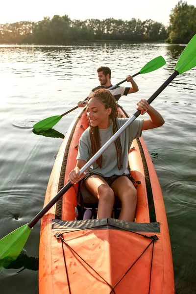 Aventurera joven novia remando kayak en un río junto con su novio en una tarde de verano —  Fotos de Stock