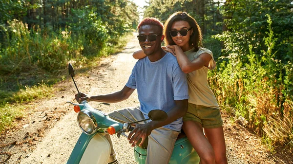Alegre casal jovem afro-americano sentado em scooter — Fotografia de Stock