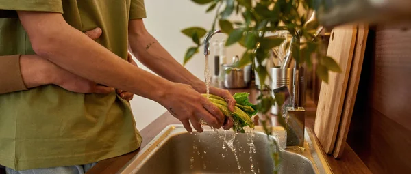 Aynı cinsiyetten erkek partnerler salata yıkarken sarılıyor. — Stok fotoğraf