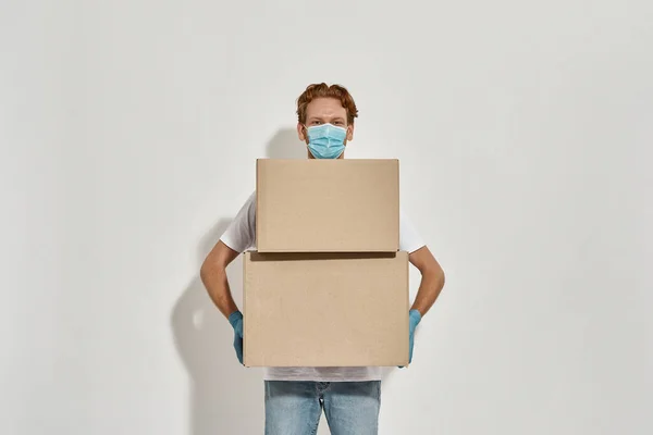 Mladý kurýr pózuje se dvěma velkými kartonovými krabicemi — Stock fotografie
