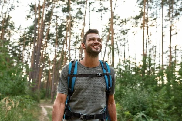 Retrato de sorrir jovem caucasiano homem trekking na floresta — Fotografia de Stock