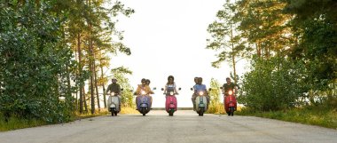 Arka arkaya motosiklet süren mutlu gençler.