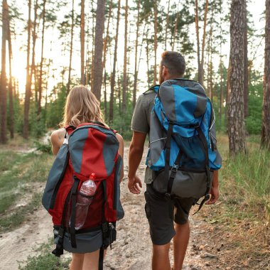 Turist sırt çantalı beyaz bir çift yürüyüş yapıyor.