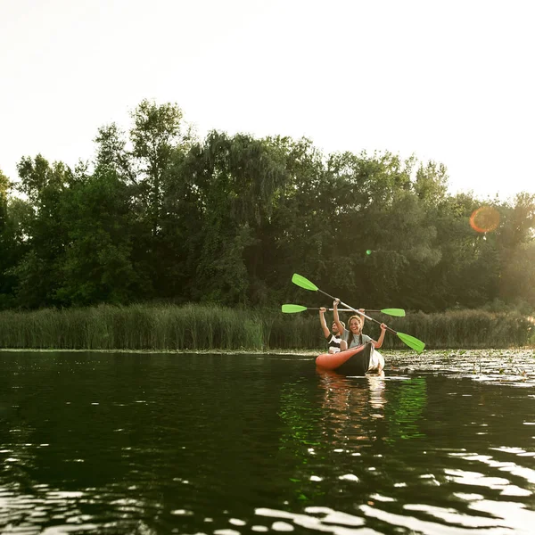 Néhány boldog barát kajakozik a folyóban, körülvéve a gyönyörű természettel egy nyári napon. — Stock Fotó
