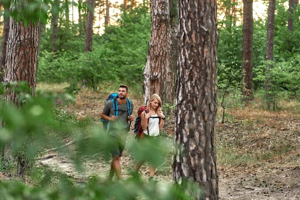 Happy young caucasian couple walking in summer forest — Stock Photo, Image