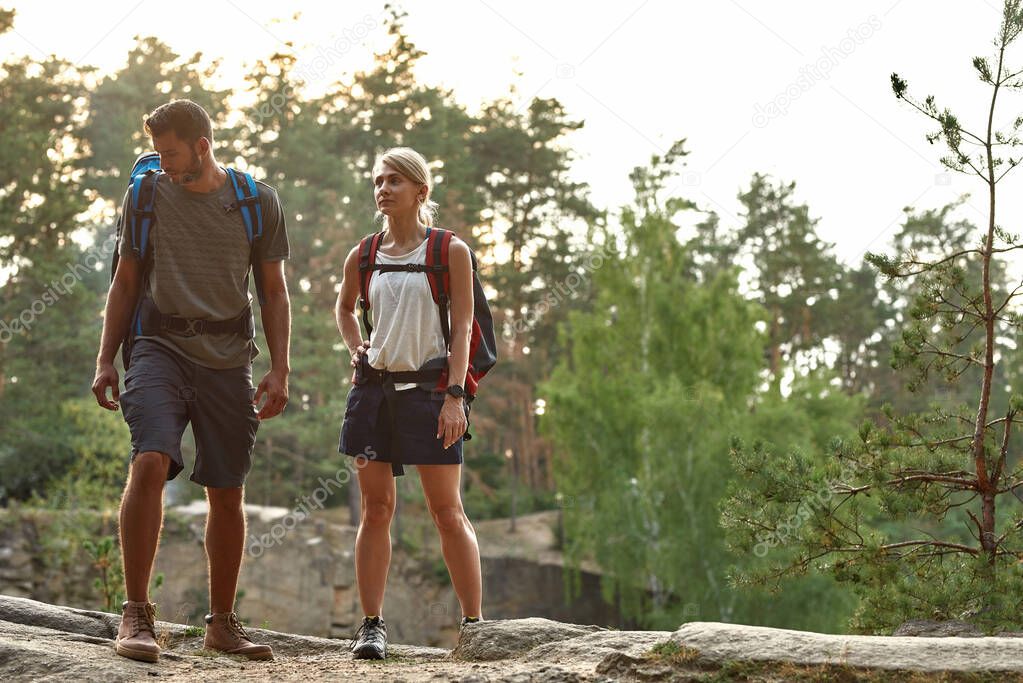 Tired young caucasian man and woman on rock